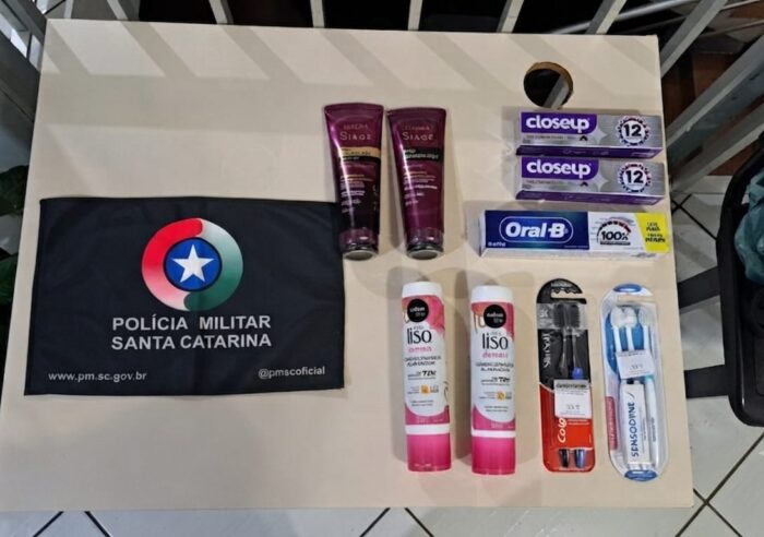 Produtos de higiene pessoal como escovas e cremes dentais recuperados pela Polícia Militar dispostos sobre uma superfície.