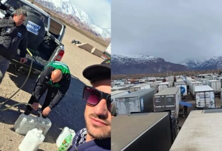 Caminhões estacionados ao lado de grande acúmulo de neve na Cordilheira dos Andes