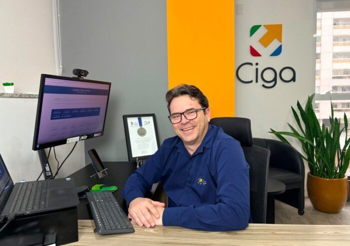 Pessoa utilizando computador com sistema de inteligência fiscal contendo gráficos e dados tributários