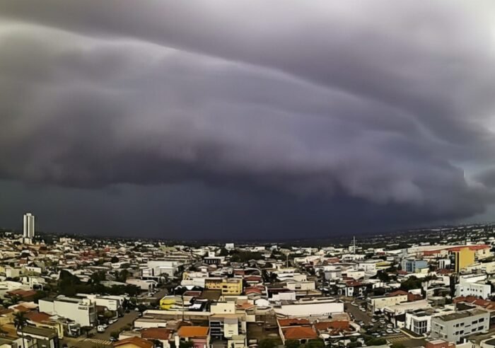 Ciclone extratropical se aproxima e provoca mudanças no tempo, com céu carregado sobre uma área urbana.