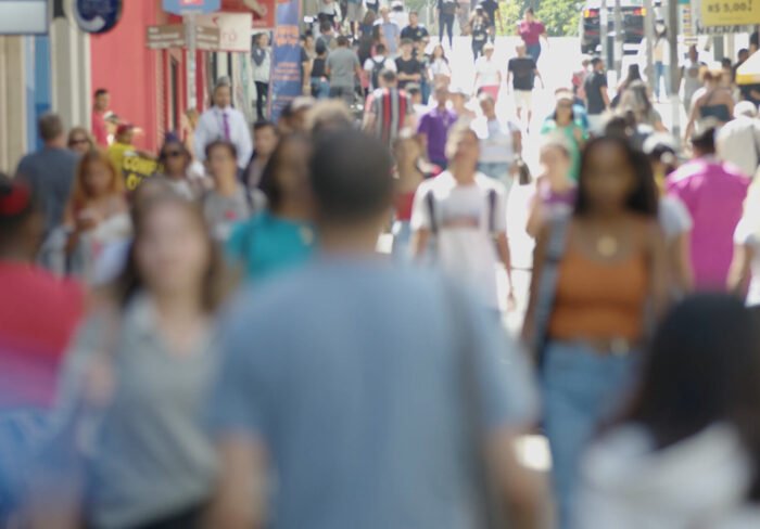 Pessoas caminhando em calçadão de área central urbana em Santa Catarina.
