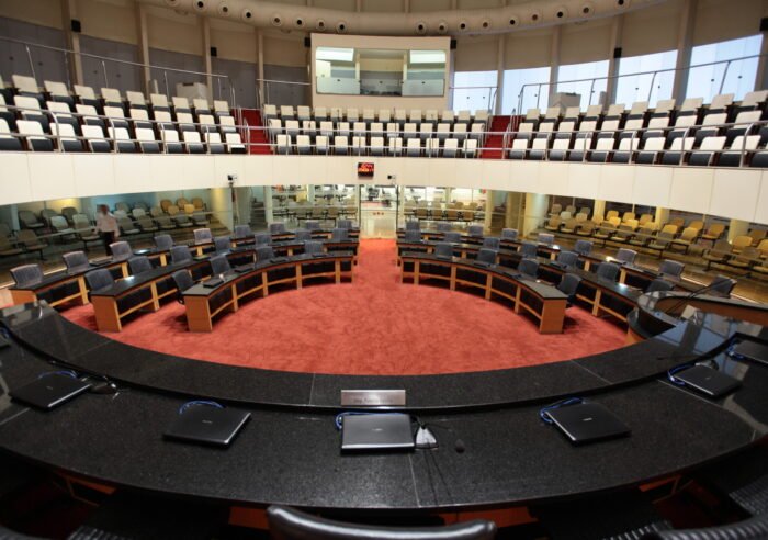 Visão geral do plenário da Assembleia Legislativa de Santa Catarina com cadeiras e bancadas vazias