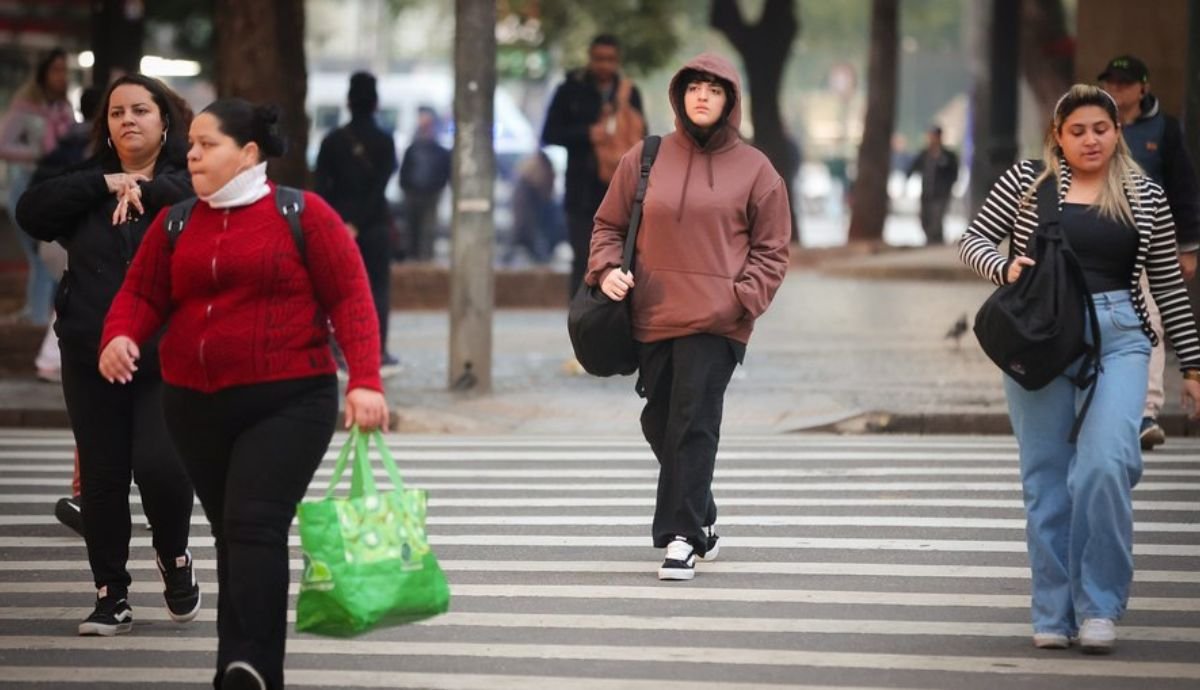 Pessoas andando de casaco na rua