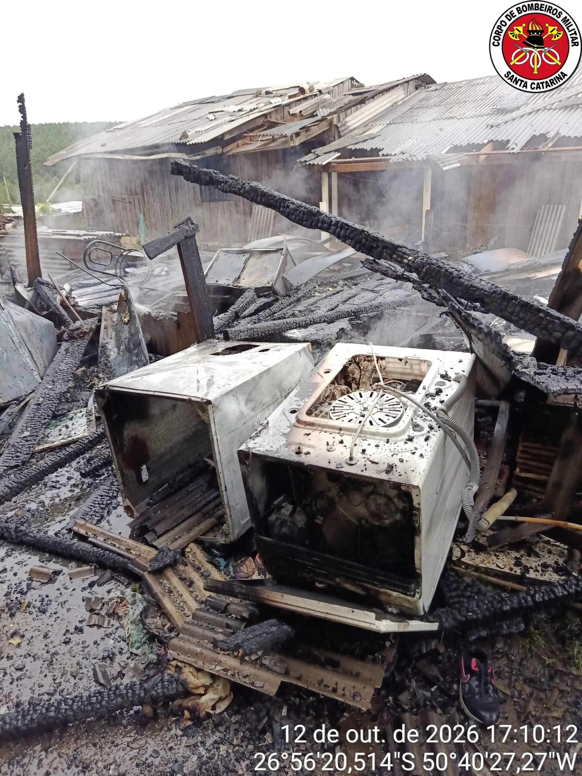 Restos de eletrodomésticos e madeira queimada após incêndio que destruiu casa em Lebon Régis