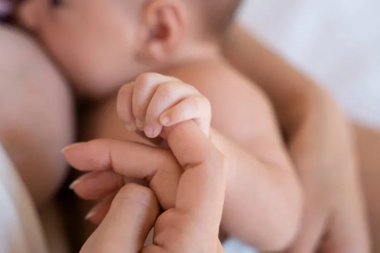 Mãe segurando bebê nos braços durante momento pós-parto