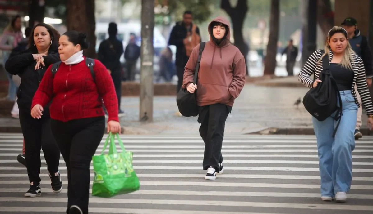 Pessoas andando de casaco na rua